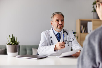 A male doctor is talking about medical treatment with a female patient at the clinic.