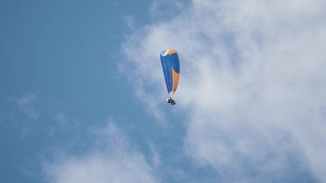 A paraglider floats in the sky 