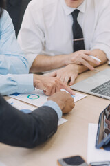 Financial analysts analyze business financial reports on a digital tablet planning investment project during a discussion at a meeting of corporate showing the results of their successful teamwork.