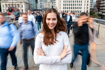 Smiling woman portrait with blurred people at rush hour in London