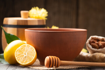 Clay bowl with honey and a wooden barrel for honey on a wooden background. Close-up.