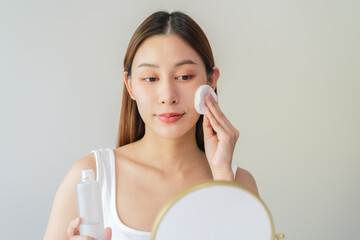Close-up view woman using toner and cotton pad to remove makeup