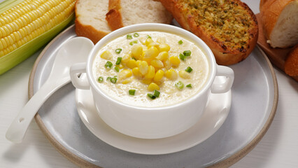 Corn Soup and Bread breakfast menu on white table