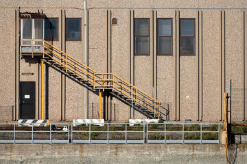 Fototapeta na wymiar Industrial building with yellow external staircase