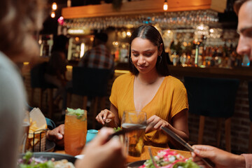 diverse group of friends out for dinner eating delicious meals