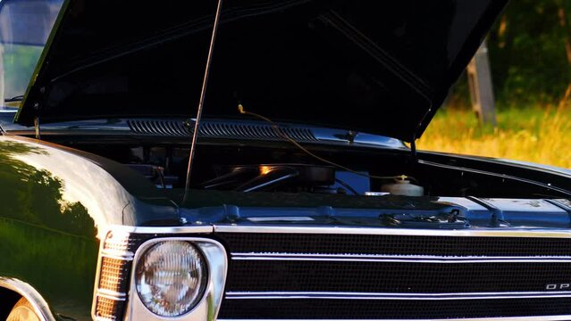 Opel Olympia classic car on a green meadow, opened hood, slider shot, 50 fps, slow motion