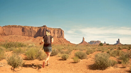 A view of a woman running through the desert, Monument Valley, USA
