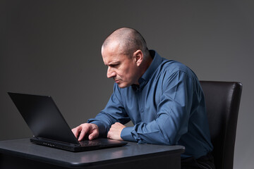 Mature businessman at his desk on his laptop