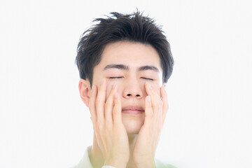 脱毛やスキンケアで使えそうなさわやかなアジア系のハンサムな男性のイメージ　目を閉じる