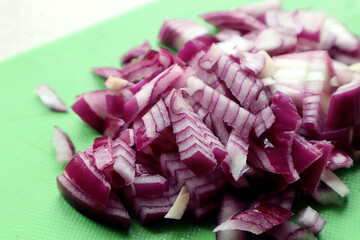 Sliced red onion lies on a green kitchen board close-up