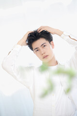 Fototapeta premium 美容系のヘアセットやシャンプーなど髪の毛のイメージに使えそうな男性のポーズ