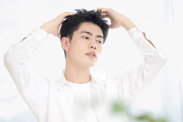 Naklejka premium 美容系のヘアセットやシャンプーなど髪の毛のイメージに使えそうな男性のポーズ