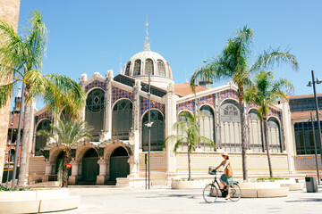 Biker in front of Central market of Valencia, Spain