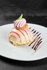 Mousse cake with berries taste and meringue on white plate on dark background. Berry cheesecake in glazed topped. Mousse cake in minimal style. Confectionery menu. Light mousse dessert.