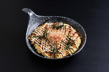 Okonomiyaki traditional japanese food isolated in black background - 575940973