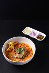 Khao Soi Thai Curry soup isolated in black background