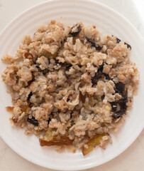 Tasty oatmeal with dried fruits, top view.