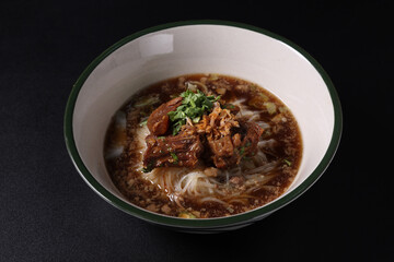 Braised pork noodles Thai street food isolated in black background