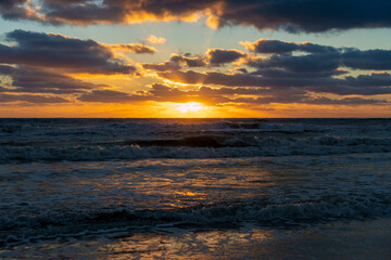 Ocean sunset landscape with soft evening sea water waves crushing on sandy beach