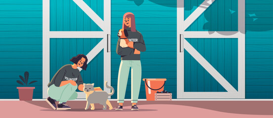 young man woman volunteers with dog and cat animals standing near barn generation Z lifestyle concept © mast3r