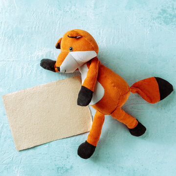 Square mockup for a kraft card with a toy fox. A greeting card or invitation design template with copy space