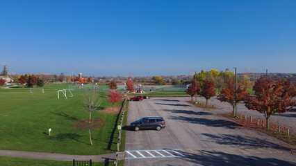 Huge grassy soccer fields near empty parking lots colorful fall foliage at community recreational center in Rochester, Upstate New York © trongnguyen