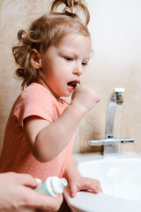 Cheerful and funny girl brushing her teeth in the morning