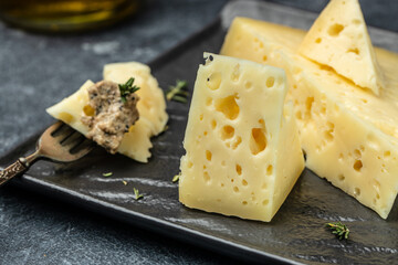 cheese with holes and mushrooms sauce, truffle paste on a black plate. banner, menu, recipe place for text, top view