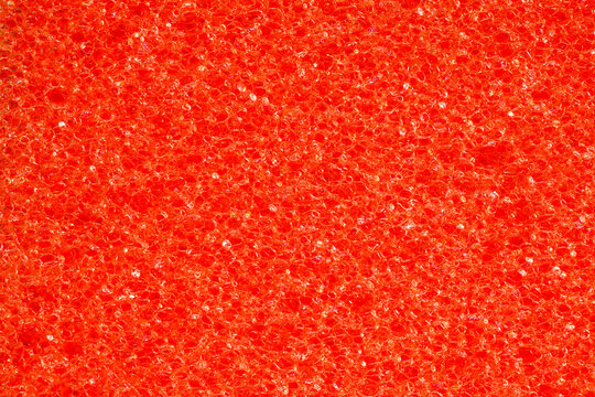 Foam rubber red sponge, pores  loose, close-up background wallpaper, uniform texture pattern