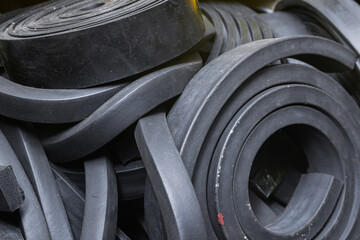 Close-up rubber sealing strips for waterproof doors. A pile of rubber twisted into rolls. - obrazy, fototapety, plakaty