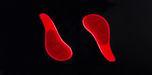 Two red hair combs on the black background. Copy space. Top view.