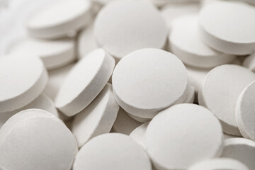 Fototapeta na wymiar Tablets round white medical many in bulk, selective focus