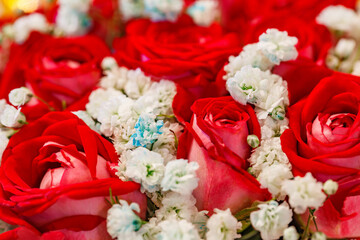 Flowers red roses and small white in bouquet, close-up selective focus