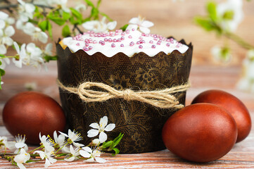 Easter cake, colored eggs and blossoming cherry branches. Easter card. Close-up. Selective focus.