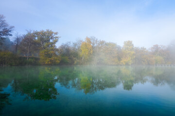 Fototapeta na wymiar Autumn landscape by the lake. Nature with fog in the morning. 