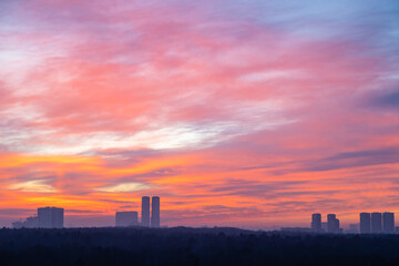 Fototapeta na wymiar colorful cloudscape over city park and towers at cold dawn