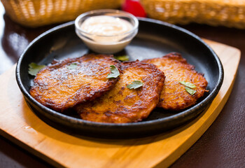 Belarusian cuisine. Appetizing potato draniki stew with sour cream