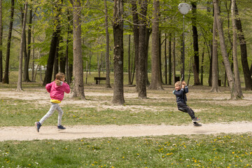 Children running around playing in the park in the spring