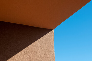 Brown and orange wall against a blue sky.