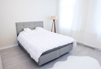 Fototapeta na wymiar White covered bed in bedroom