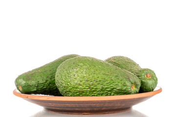 Three juicy avocados on a clay plate, macro, isolated on a white background.