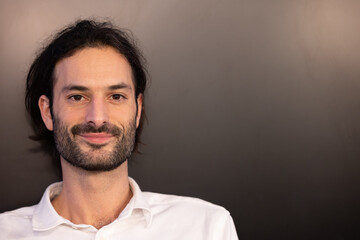 portrait d'un beu jeune homme souriant qui regarde la caméra
