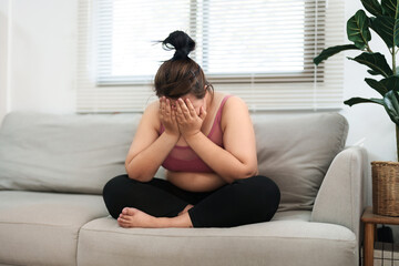 overweight woman sitting on the sofa stress about loss weight.. - obrazy, fototapety, plakaty