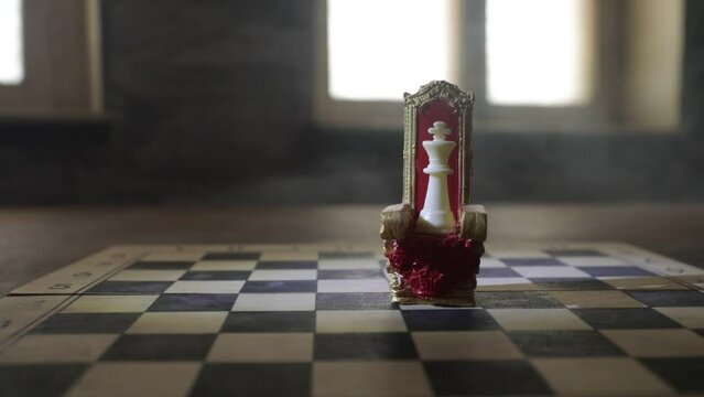 Red royal chair (Medieval Throne) miniature on chessboard. . Chess board game concept of business ideas and competition and strategy ideas concept. Selective focus