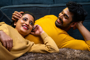 Fototapeta premium Happy young couple spending romantic time while sleeping on floor during weekend holidays at home - concept of caring, relationship bonding and understanding each other