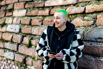 Young androgynous woman smiling with green colored hair