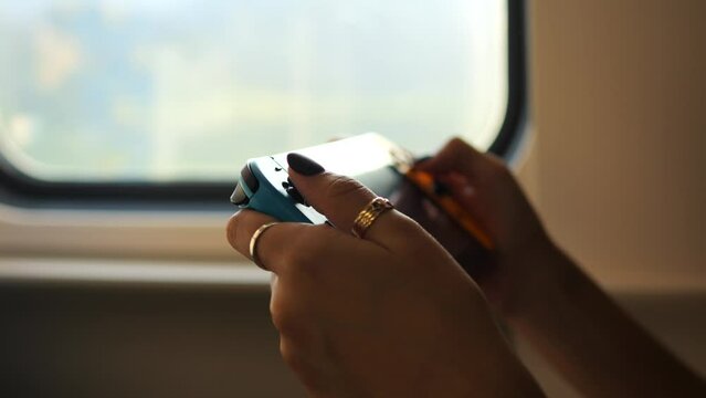 Nerd Girl Playing on Portable Video Game Console in Train, High Quality 4K Slow Motion Cybersport Gaming in Transport Concept Footage.