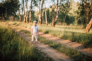 Portrait of a happy cute little boy having fun outdoors, exploring summer nature forest.