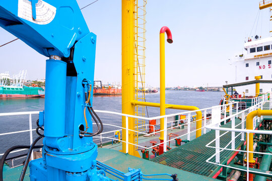 Selective Focus At Blue Crane Machine On Steel Walkway Over Gas Pipelines System In Oil Tanker Ship At Harbor, Perspective Side View