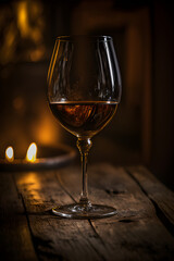 A close-up of a glass of wine, reflections of the wine visible through the glass, on a rustic wood table, AI, generated by AI